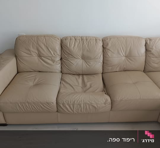 ספת עור בצבע קרם עם כרית ישיבה שקועה הדורשת תיקון ומילוי